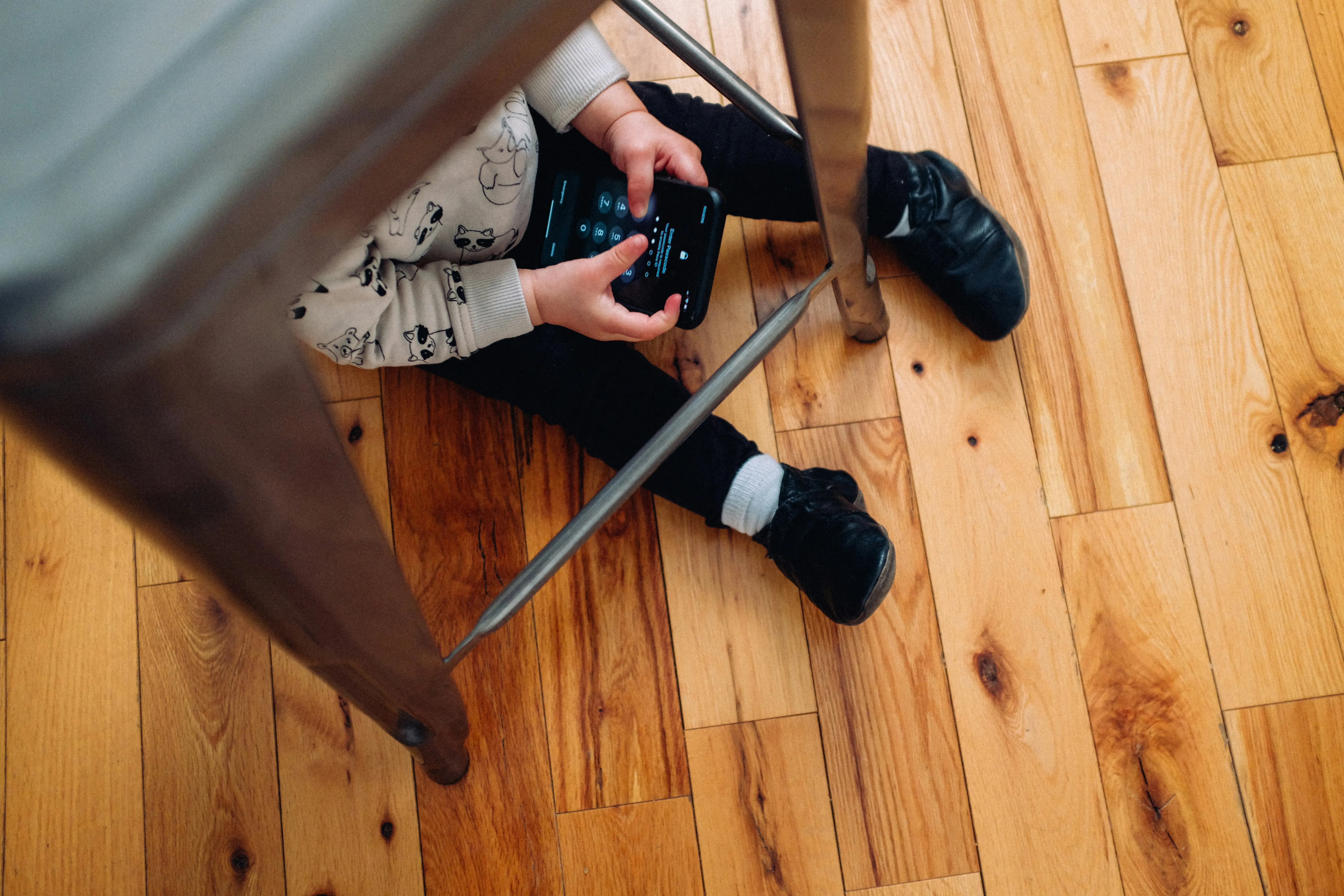 A child hiding playing with a smart phone